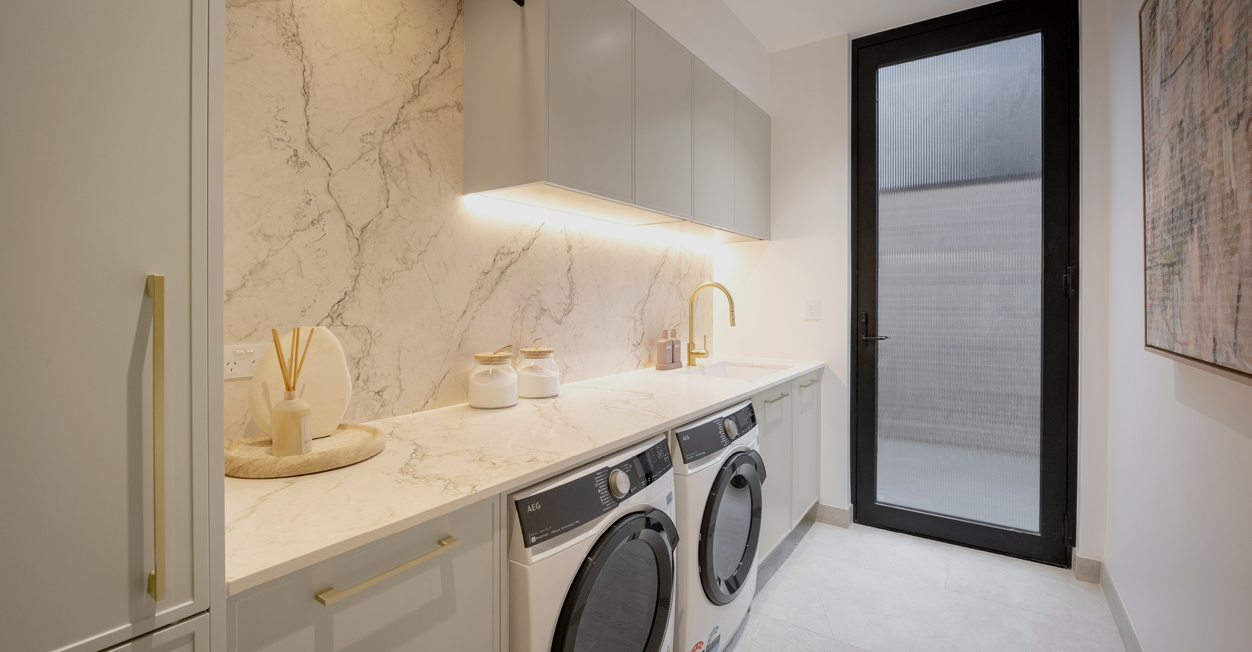 Modern Australian kitchen with timber cabinetry, marblelook benchtops and pendant lighting by Kinsman