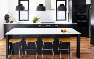 shaker style kitchen with black cabinetry, white countertops and a large island