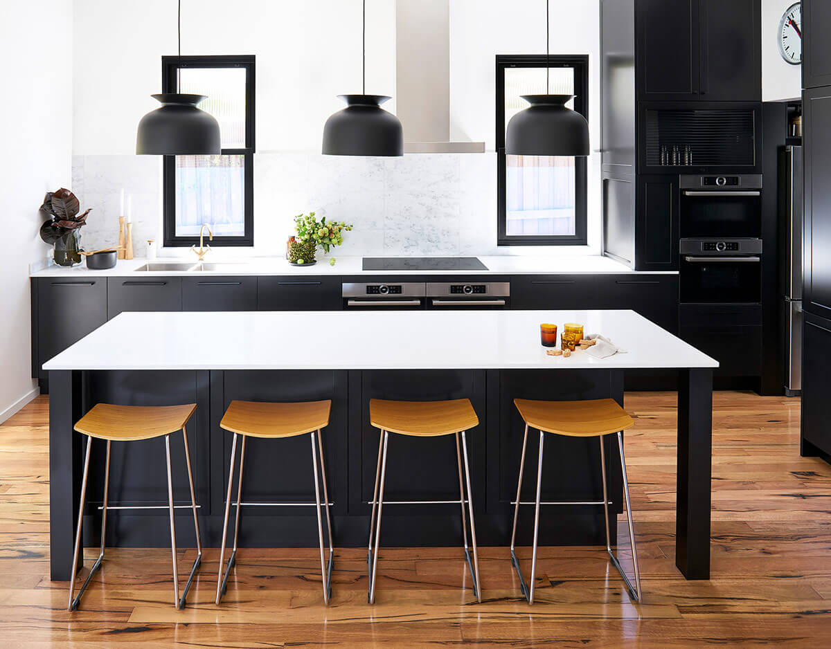 shaker style kitchen with black cabinetry, white countertops and a large island