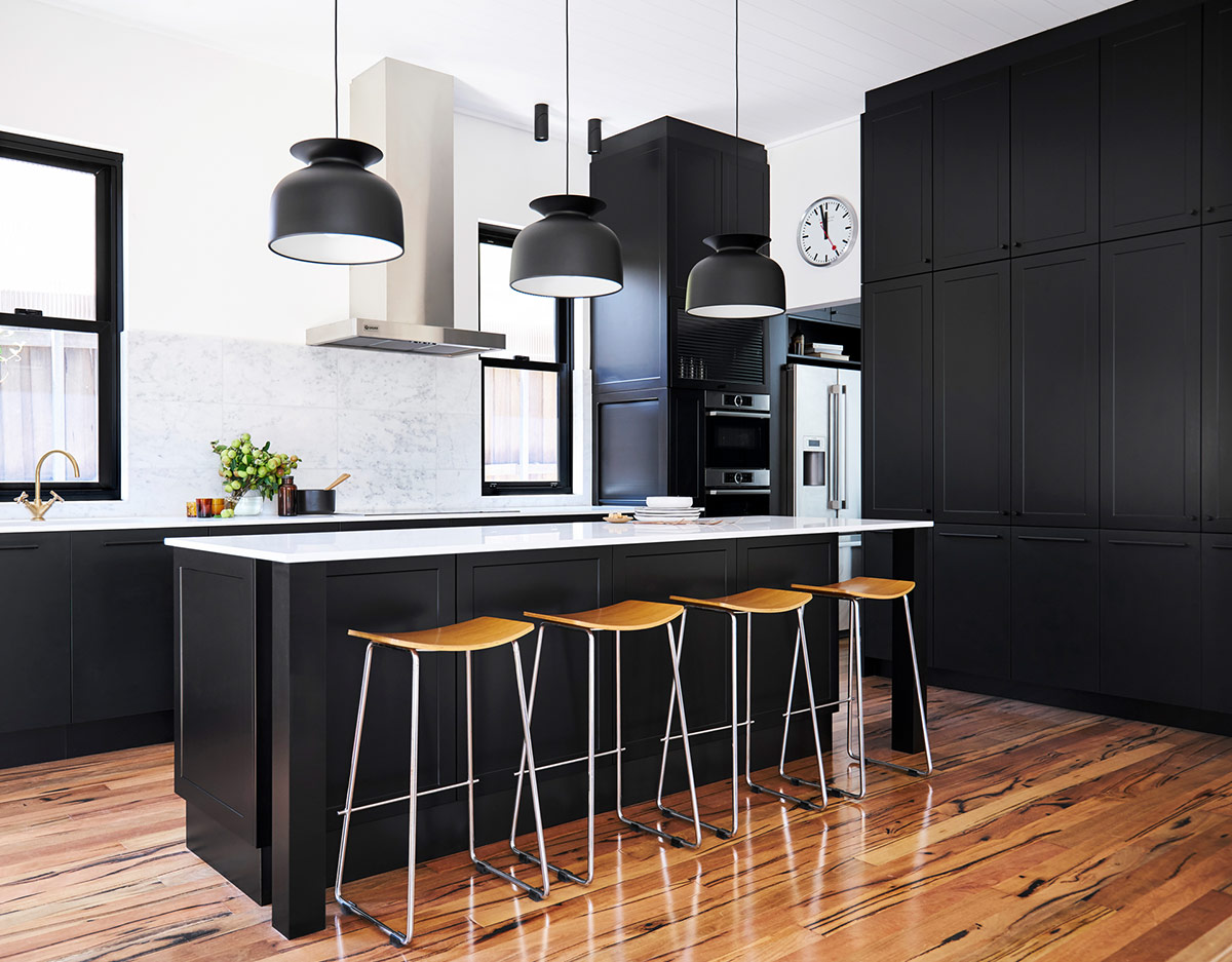 shaker style kitchen with black cabinetry, white countertops and a large island