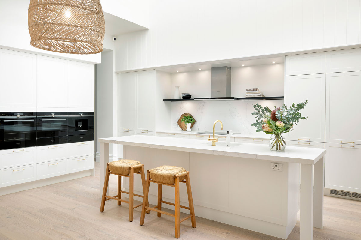 Modern shaker style kitchen with white cabinets, black countertops and stainless steel appliances