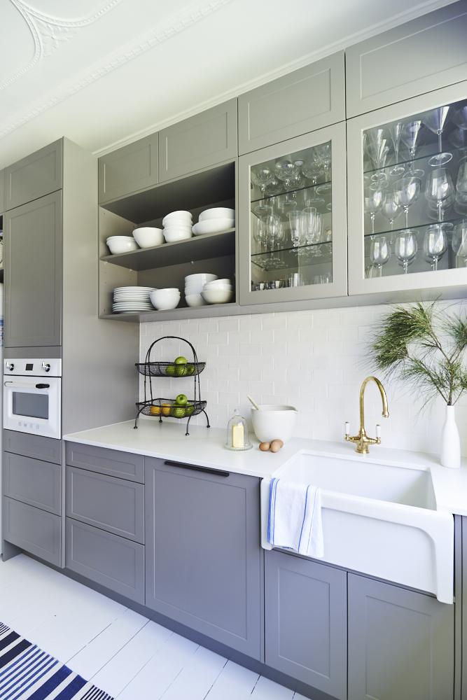 Elegant shaker style kitchen with grey cabinetry, white countertops and a large center island