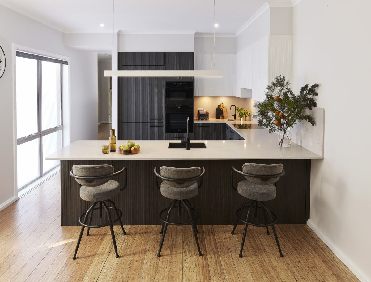 Kitchen with dark cabinetry, island bench and bar stools