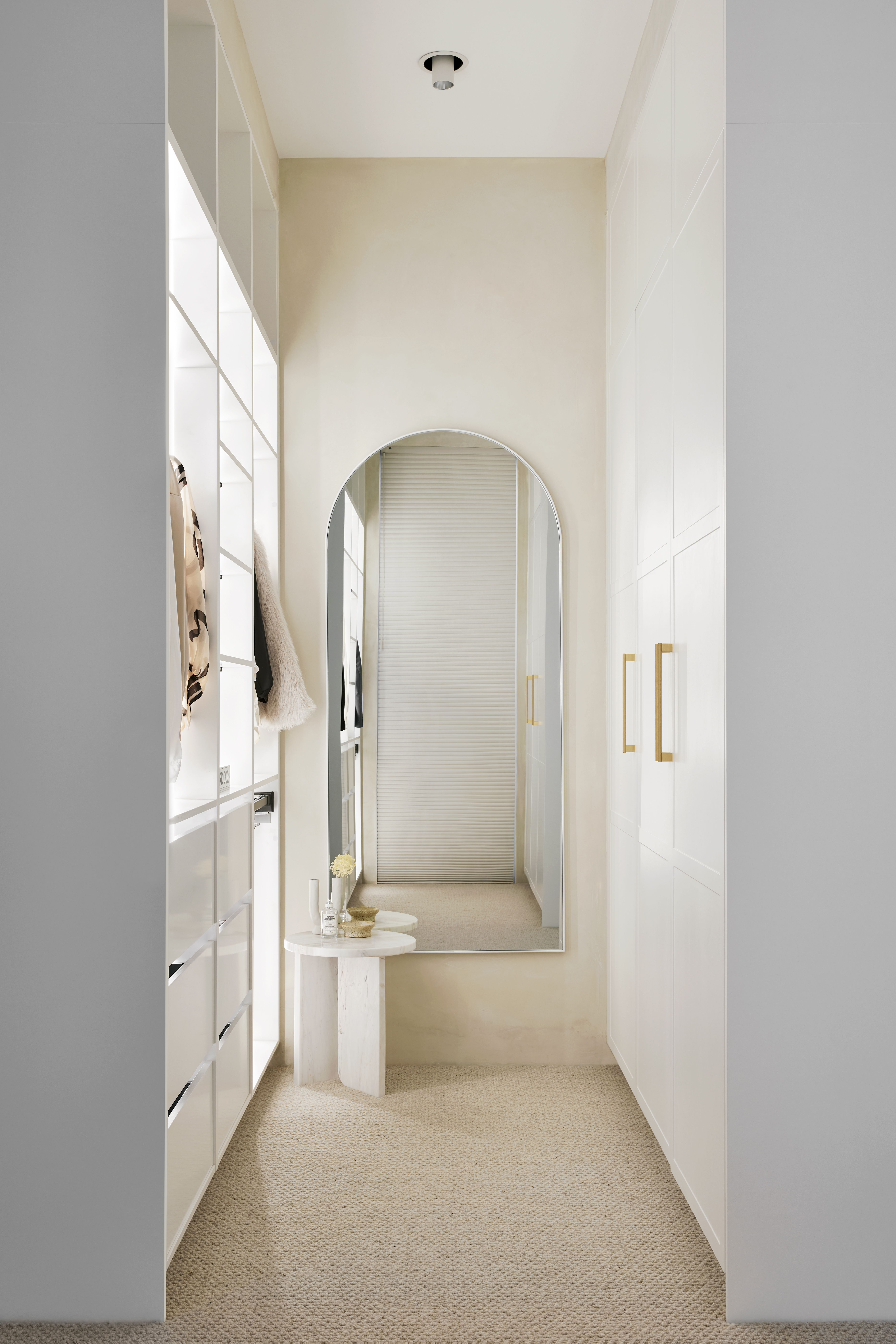 Luxury walk in wardrobe with white shaker doors, gold handles and open hanging space