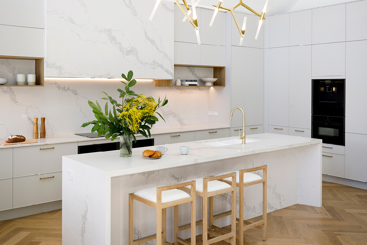 8-reno-tips-1 Modern L-shaped kitchen with neutral coloured cabinetry and a large island bench