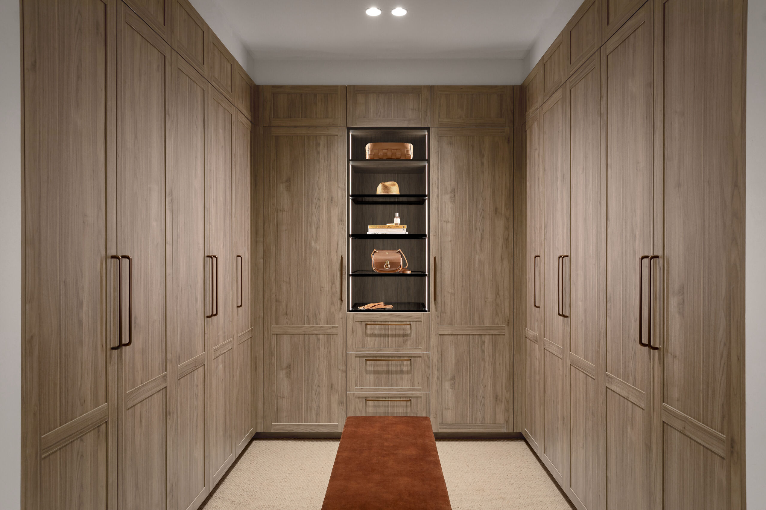 U-shaped walk in wardrobe with dark timber cabinetry