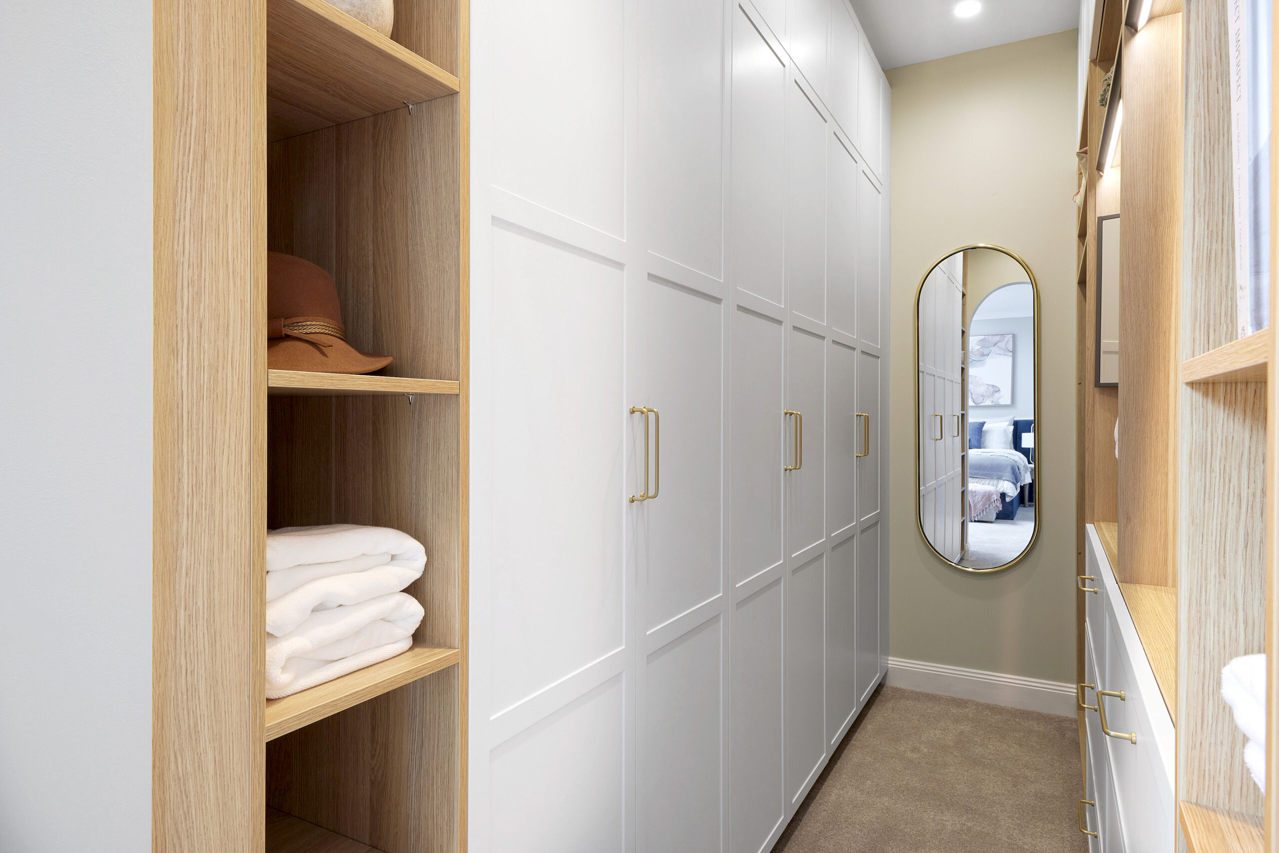 Walk in wradrobe with white and timber doors and cabinetry