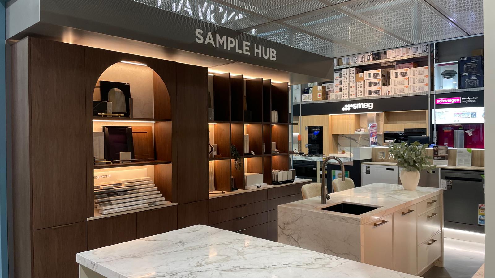 Sample Hub with dark-shelved display wall with product samples.
