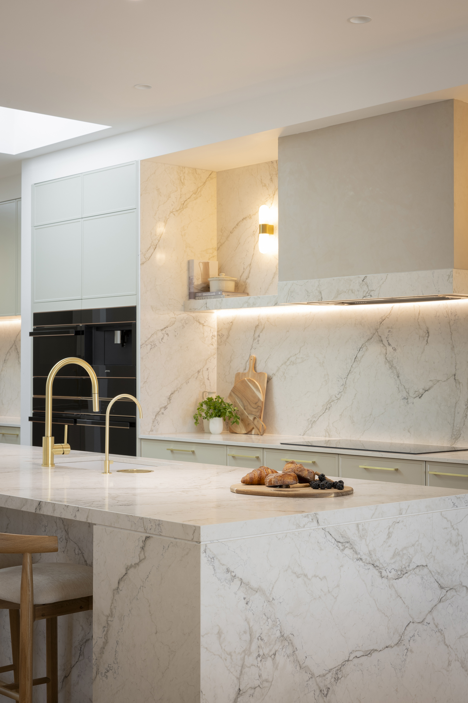 MA146 Brushed brass kitchen mixer with a mini water filter tap on a marble-look waterfall island in Chantel & Wyatt’s kitchen