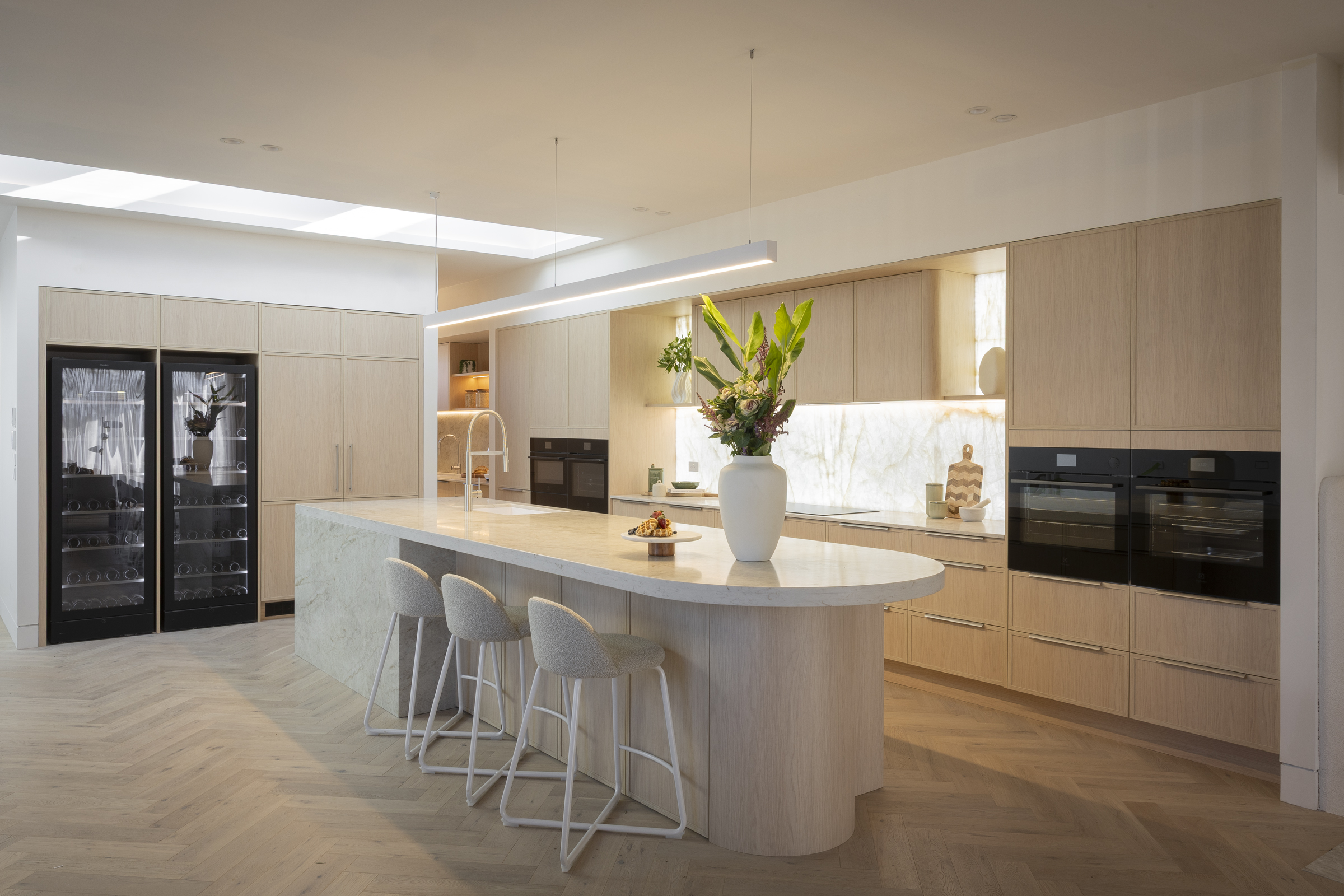 MA292 Kitchen island with curved end, white bar stools and oak-toned cabinetry