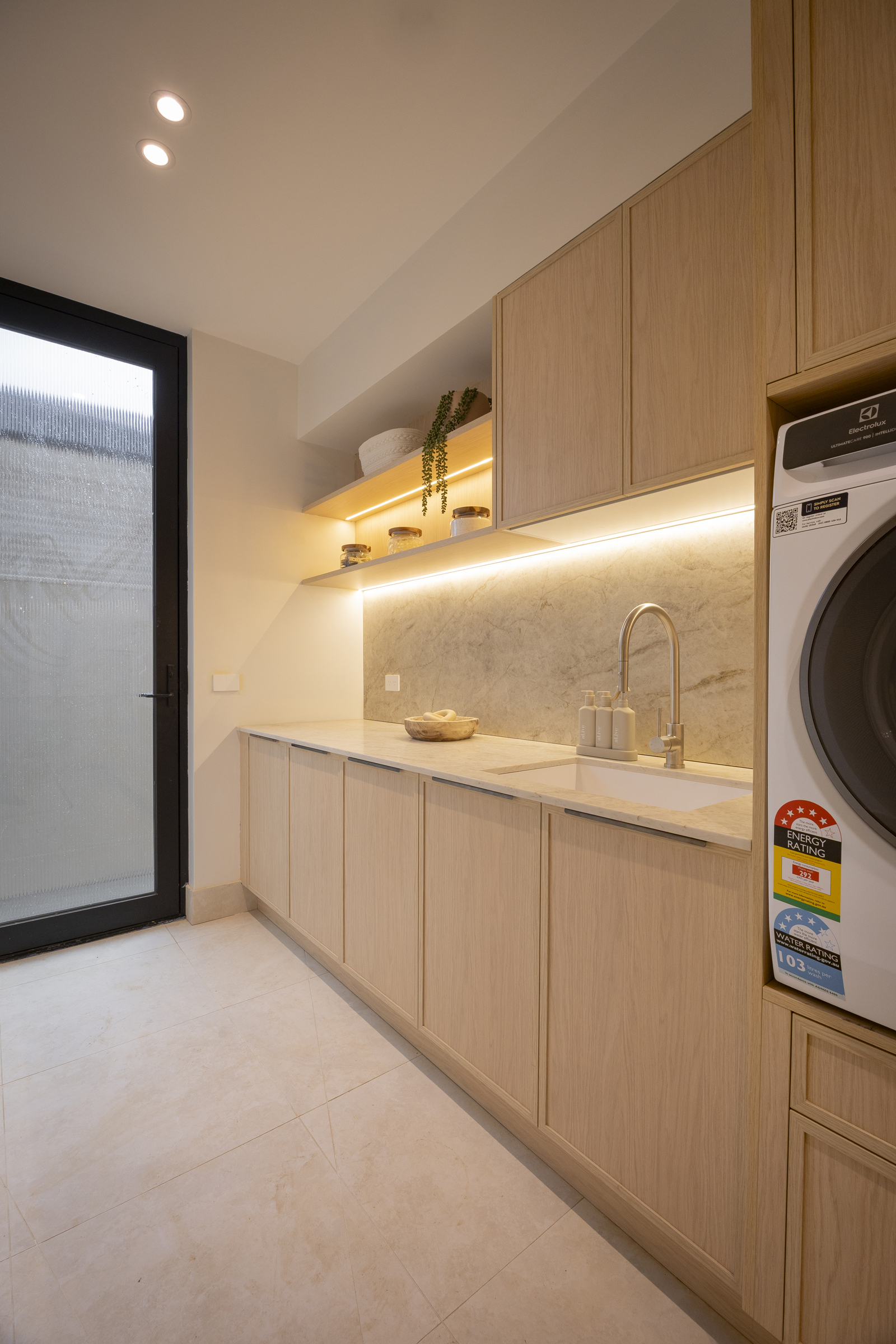 Laundry with Eclos Tajnar benchtop and splashback and light timber-look cabinetry